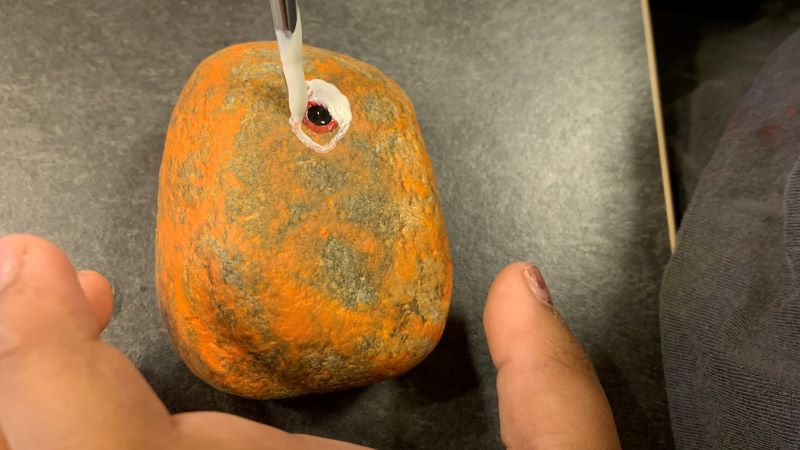 Barn målar på en sten