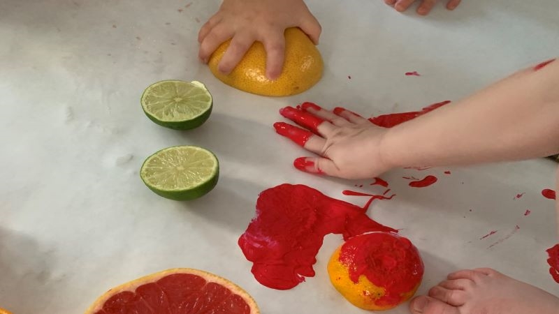 Barn gör tryck med färg och apelsin